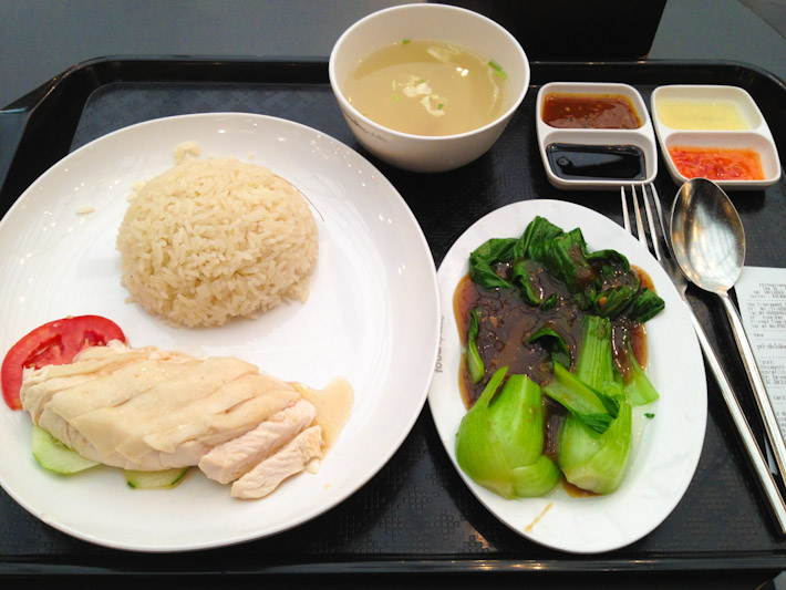 Hainanese chicken with rice, pak choi in soy sauce, a cup of chicken broth and plenty of topping to season it all