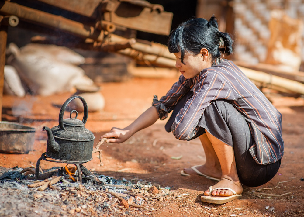 Burmese woman cooking with firewood